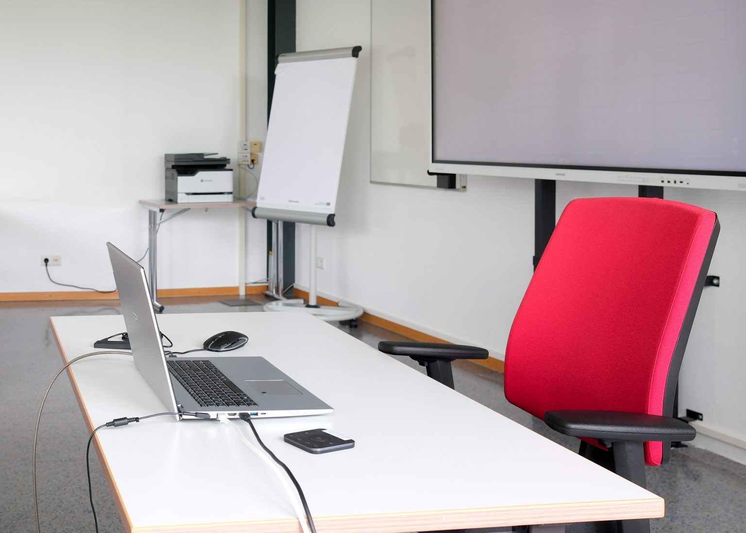 Laptop und roter Stuhl im Schulungsraum, Weiterbildung Förderung NRW